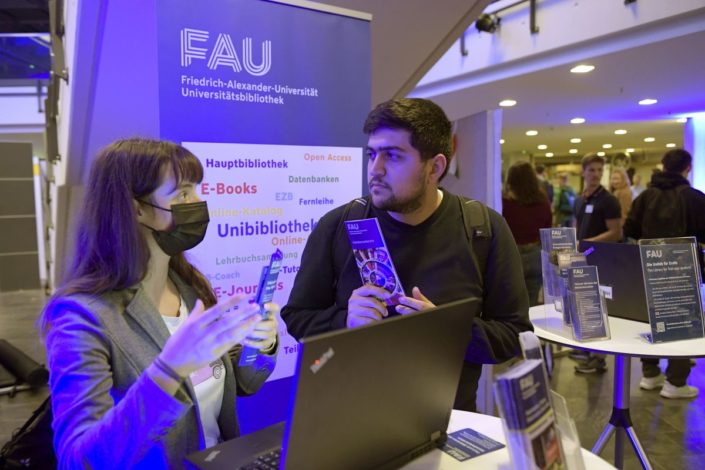 Beratung am Infostand der Universitätsbibliothek bei der Erstsemesterbegrüßung in der Heinrich-Lades-Halle