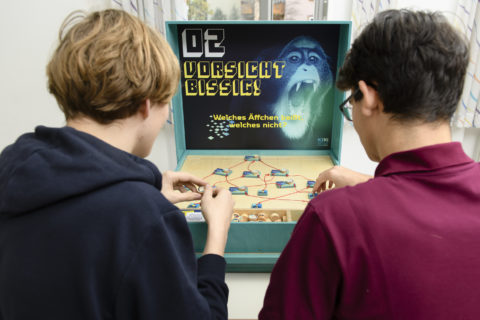 Zwei junge Männer spielen das Spiel ''Vorsichtig bissig''
