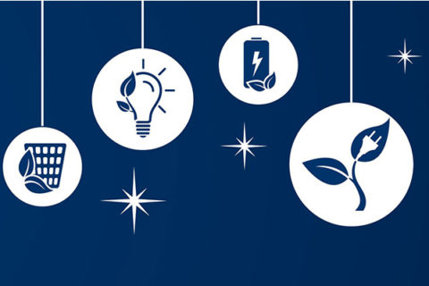 Auf blauem Hintergrund steht Recycling-Symbol, Glühbirne, Solarzellen, Batterie und Mülleimer mit Blättern als Weihnachtskugeln.