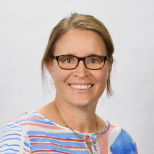 Photo of a woman in glasses wearing a red and blue top.