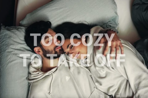 Mann und Frau liegen einander im Bett im Arm und schlafen - in FAU-Hoodies