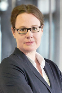 A woman with glasses and long brown hair.