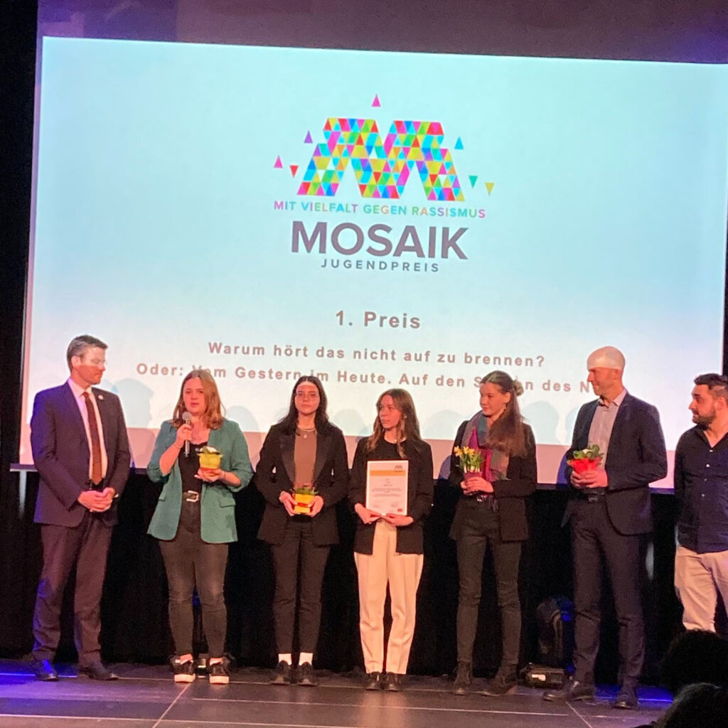 The winners of the Mosaik Youth Award receiving the award on stage.