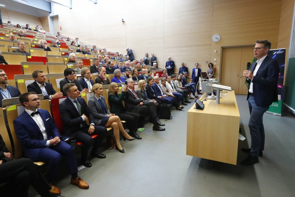 View of lecture hall. Markus Blume is standing at the lectern.