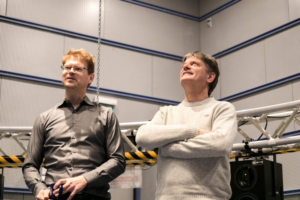 Zwei Männer stehen in einem Audiolabor.