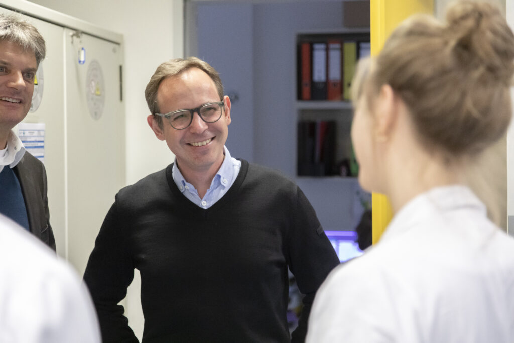 Prof. Dr. Veith Rothhammer und Prof. Dr. Joachim Hornegger im Gespräch mit einer Kollegin.