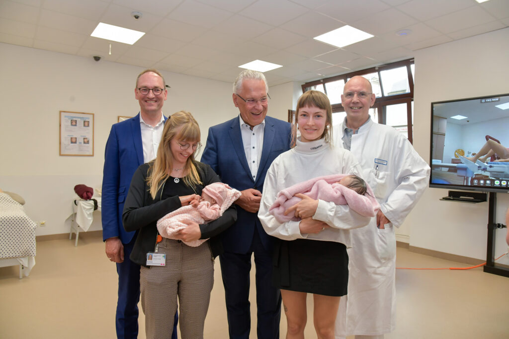 Gruppenbild: Drei Männer und zwei Frauen. Die Frauen haben Baby-Puppen im Arm.