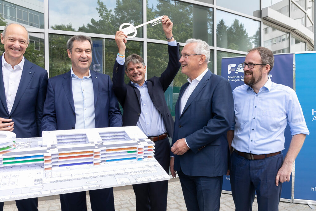 Group photo with key and model of building.