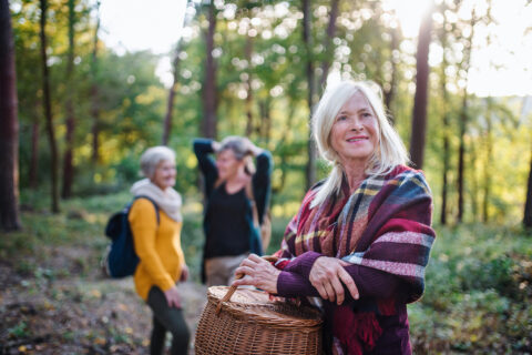 Drei ältere Frauen unterwegs im Wald.