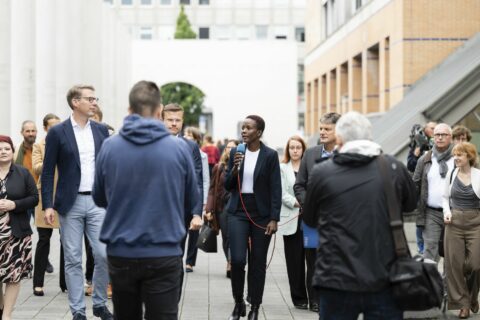 FAU-Doktorandin Aneth Lwakatare-Thumm erklärt Wissenschaftsminister Markus Blume, Nürnbergs Oberbürgermeister Marcus König und FAU-Präsident Joachim Hornegger (v.l.) Säule Art. 25 „Recht auf angemessenen Lebensstandard“ der Menschenrechte. (Bild: FAU/Uwe Niklas)