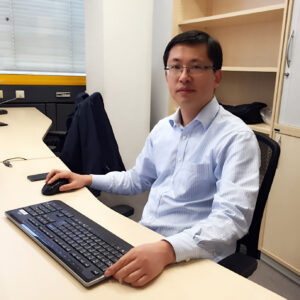 Man sitting at desk looks into the camera.