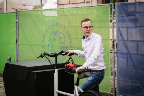 David Brenner auf einem Lastenrad. Er ist Klimaschutzmanager der FAU