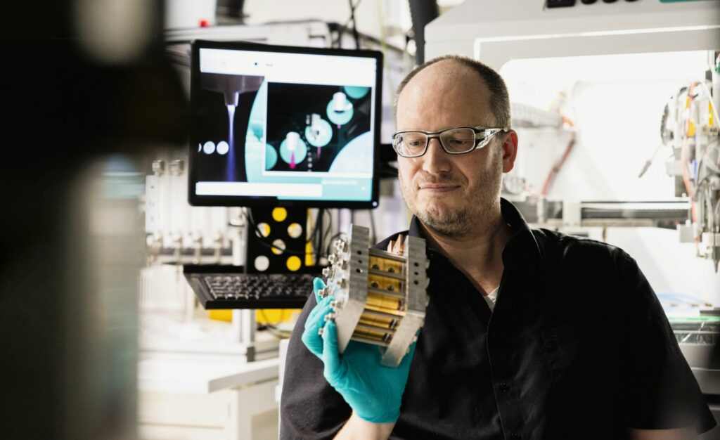Simon Thiele prüft eine Testzelle für die alkalische Elektrolyse.