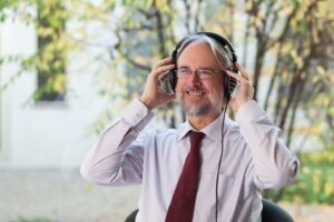 Karlheinz Brandenburg setzt sich Kopfhörer auf.