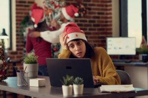 Festive people disturbing stressed woman during christmas time, feeling frustrated by noisy colleagues. Coworkers celebrating winter holiday season, interrupting tired person. Tripod shot.