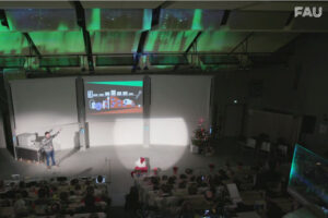 Screenshot aus der Weihnachtsvorlesung zeigt Hörsaal mit Präsentation, Publikum und Weihnachtsmann