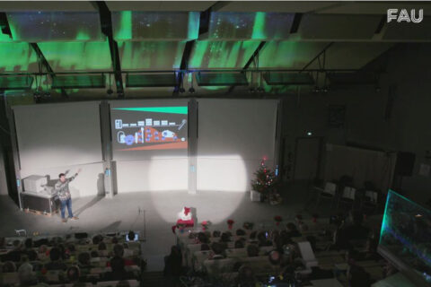 Screenshot aus der Weihnachtsvorlesung zeigt Hörsaal mit Präsentation, Publikum und Weihnachtsmann