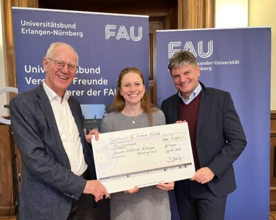 Patrizia Stumpf überreicht die Spende an Prof. Dr. Joachim Hornegger, Präsident der FAU und Dr. Siegfried Balleis, Vorsitzender des Universitätsbunds.