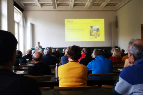 Senioren und andere Menschen in Hörsaal der FAU im Kollegienhaus