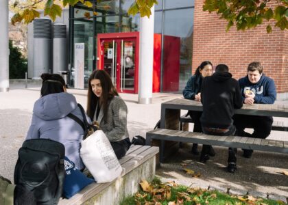 Studierende vor der WiSo in Nürnberg draußen auf Bänken
