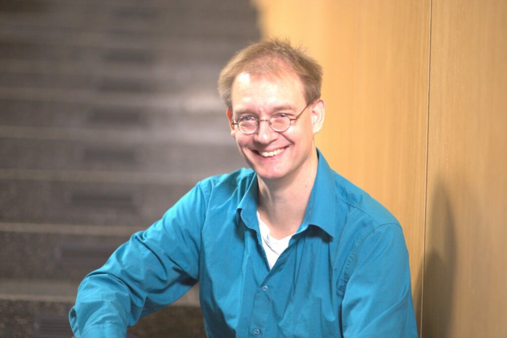 Wolfgang Wiese, Abteilungsleiter am Rechenzentrum der Friedrich-Alexander-Universität Erlangen-Nürnberg sitzt auf einer Treppe