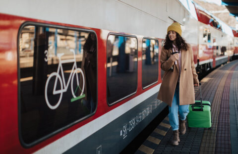 Frau läuft an einem Zug der Deutschen Bahn vorbei.