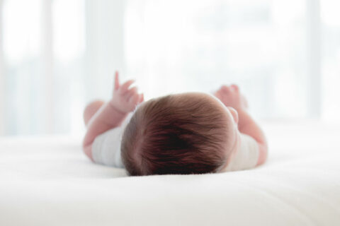 Fotografie eines Babys, das auf dem Rücken liegt und schläft.