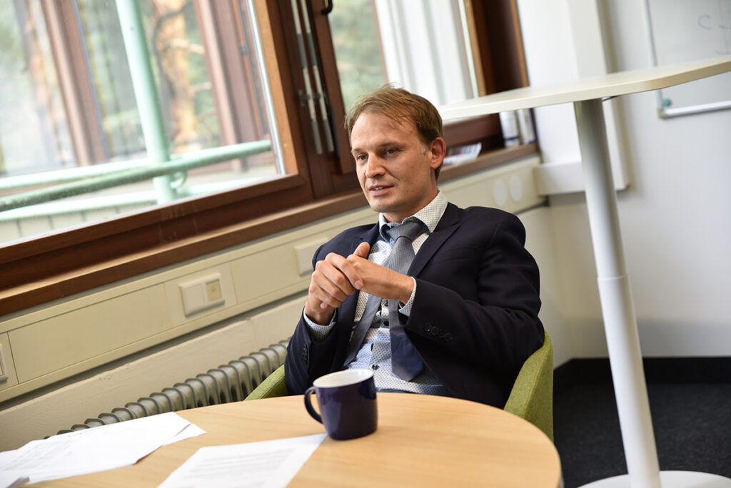 Christopher Eichler sitting at a table with an FAU mug in front of him. 