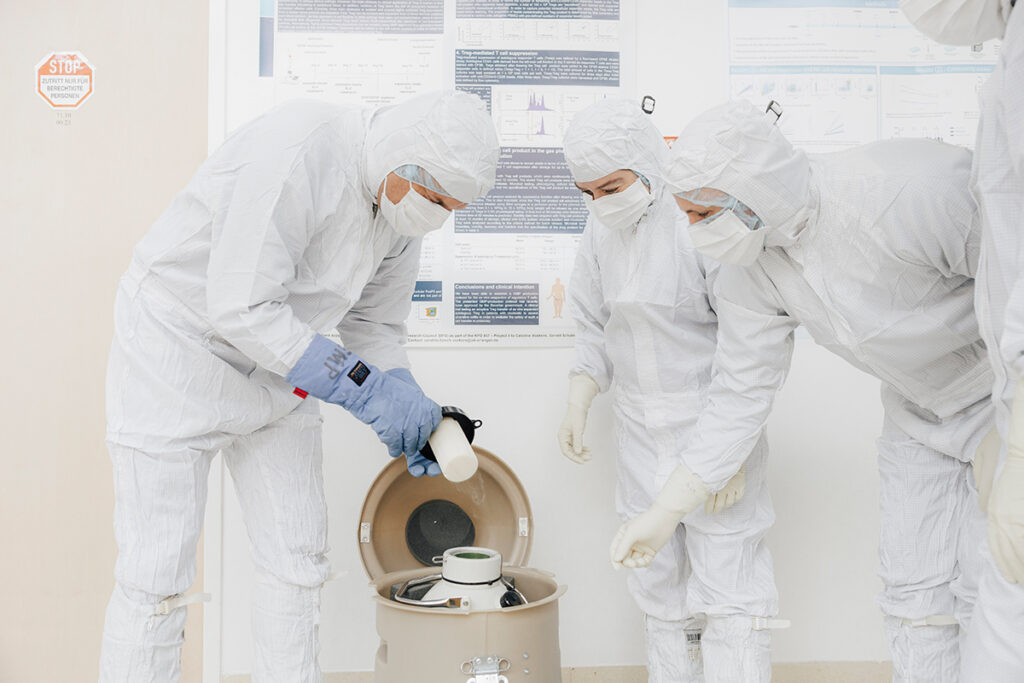 Hornegger, Voskens and staff members in protective clothing put a specimen back into a safety container. 