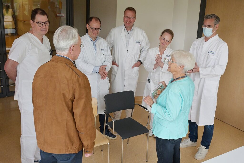 Das Ehepaar P. und die behandelnden Ärzte. Sieglinde P. hält eine Dankeskarte in der Hand. 