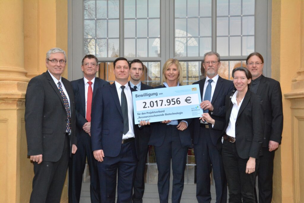 Ulrike Scharf (Mitte), Bayerische Ministerin für Umwelt und Verbraucherschutz, hat bei der Auftaktveranstaltung den Bewilligungsbescheid für den Forschungsverbund BayBiotech über 2 Millionen Euro übergeben. Prof. Dr. Rainer Buchholz (dritter von rechts), Lehrstuhl für Bioverfahrenstechnik an der FAU, wird das Projekt koordinieren. (Bild: StMUV)