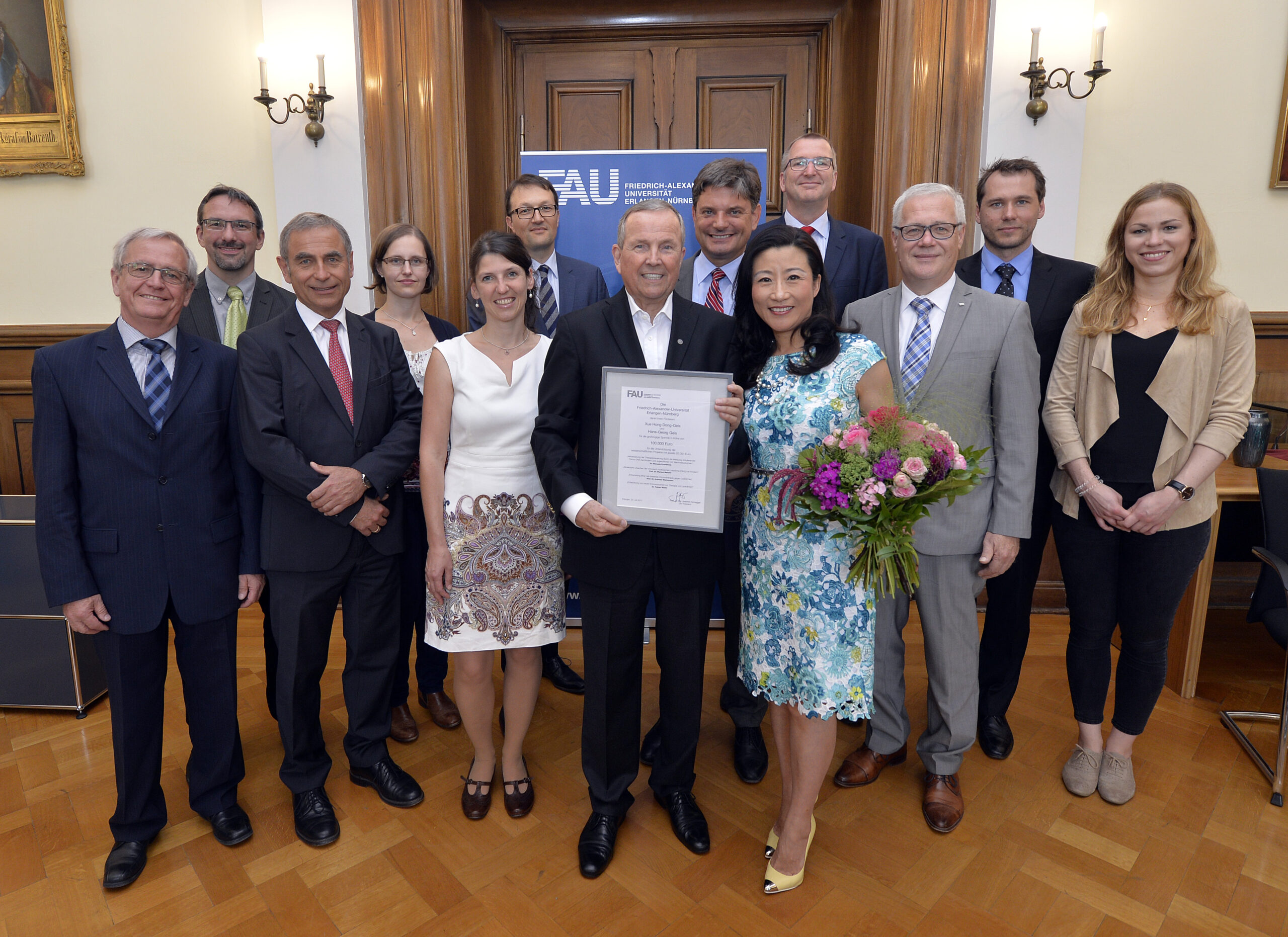 Der Unternehmer Hans-Georg Geis und seine Frau Xue Hong Dong-Geis fördern die Krebsforschung an der FAU mit einer Spende von 100000 Euro für vier Projekte. Alle Beteiligten kamen zur Übergabe der Förderurkunde ins Amtszimmer des FAU-Präsidenten Joachim Hornegger. Foto: In der Mitte der Spender mit seiner Frau, Uni-Präsident Joachim Hornegger und Kanzler Christian Zens. (Foto:FAU/Harald Sippel)