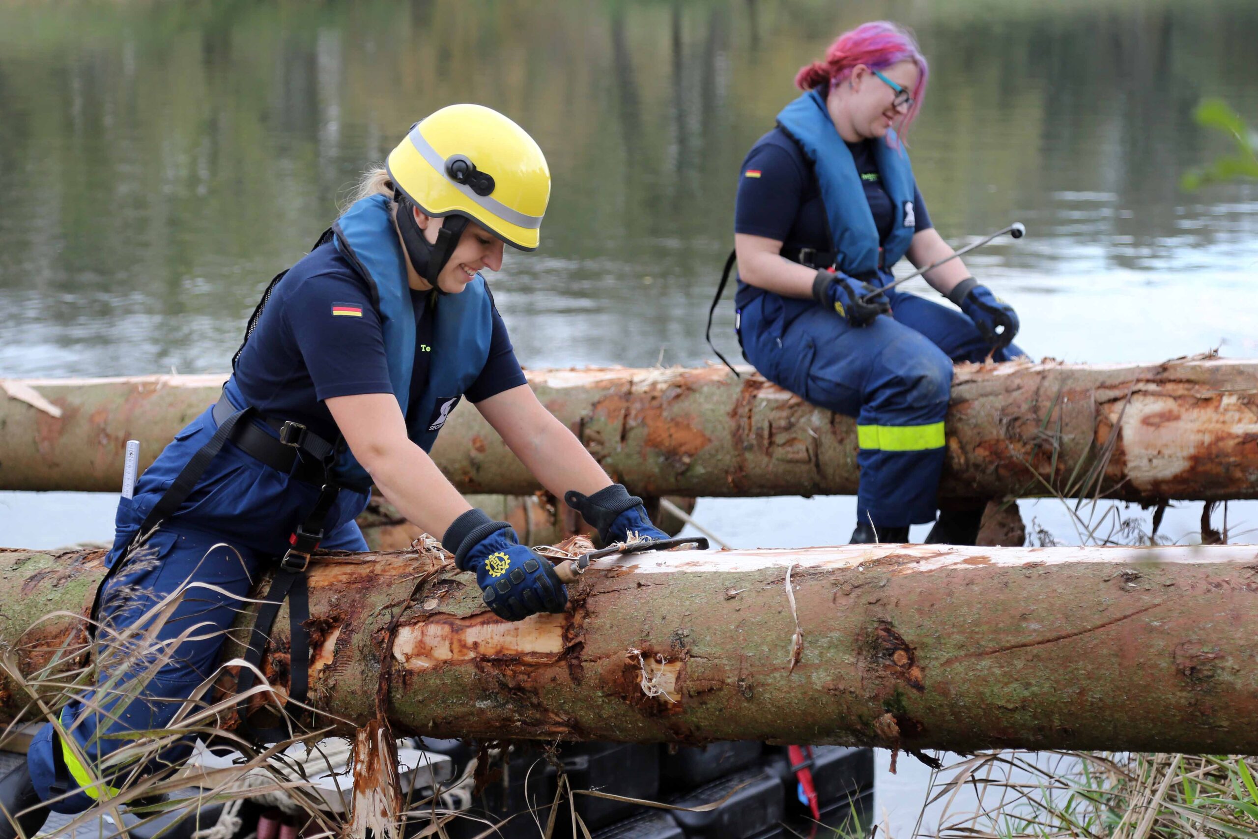 Helferinnen des Technischen Hilfswerks beim Entrinden der Baumstämme. (Bild: FAU/Matthias Orgeldinger)