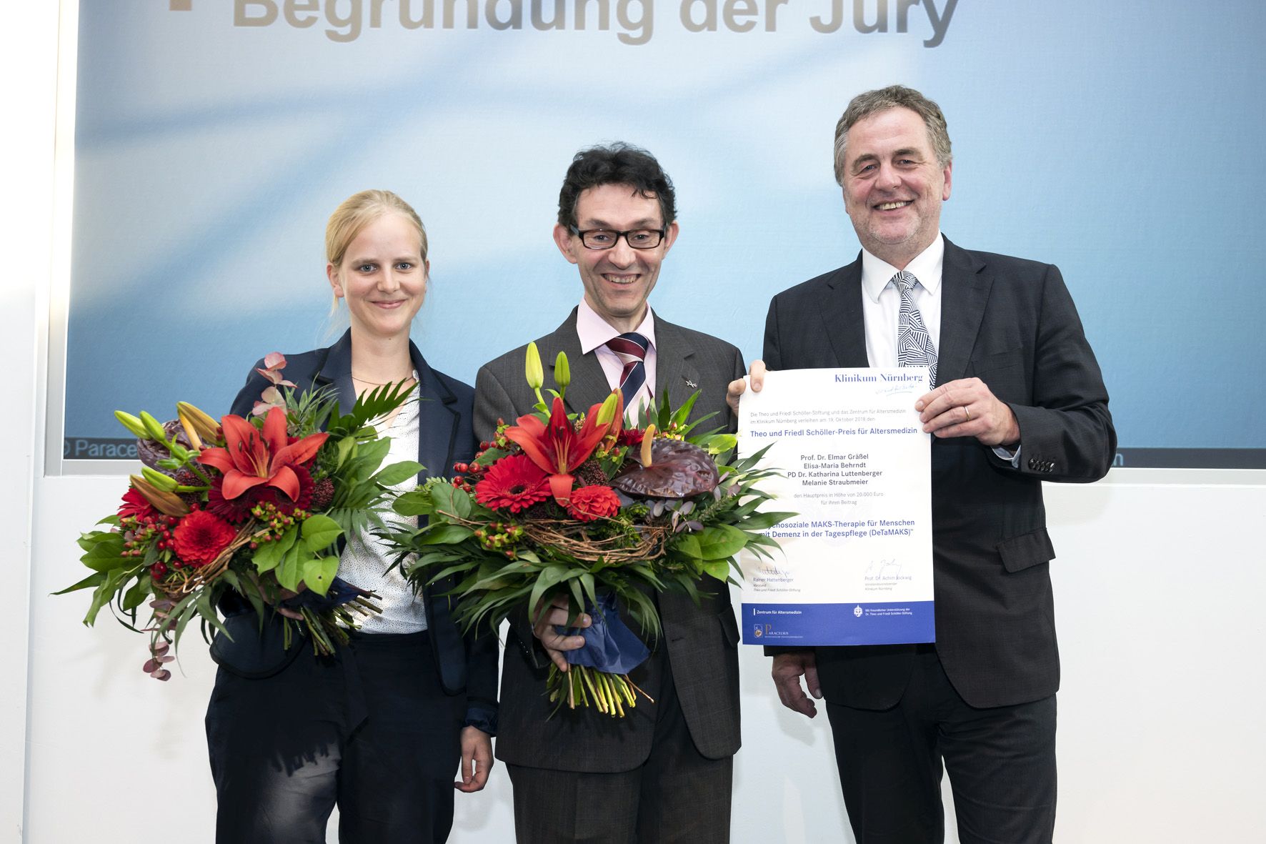 Forscher mit Blumensträußen und Übergabe Urkunde