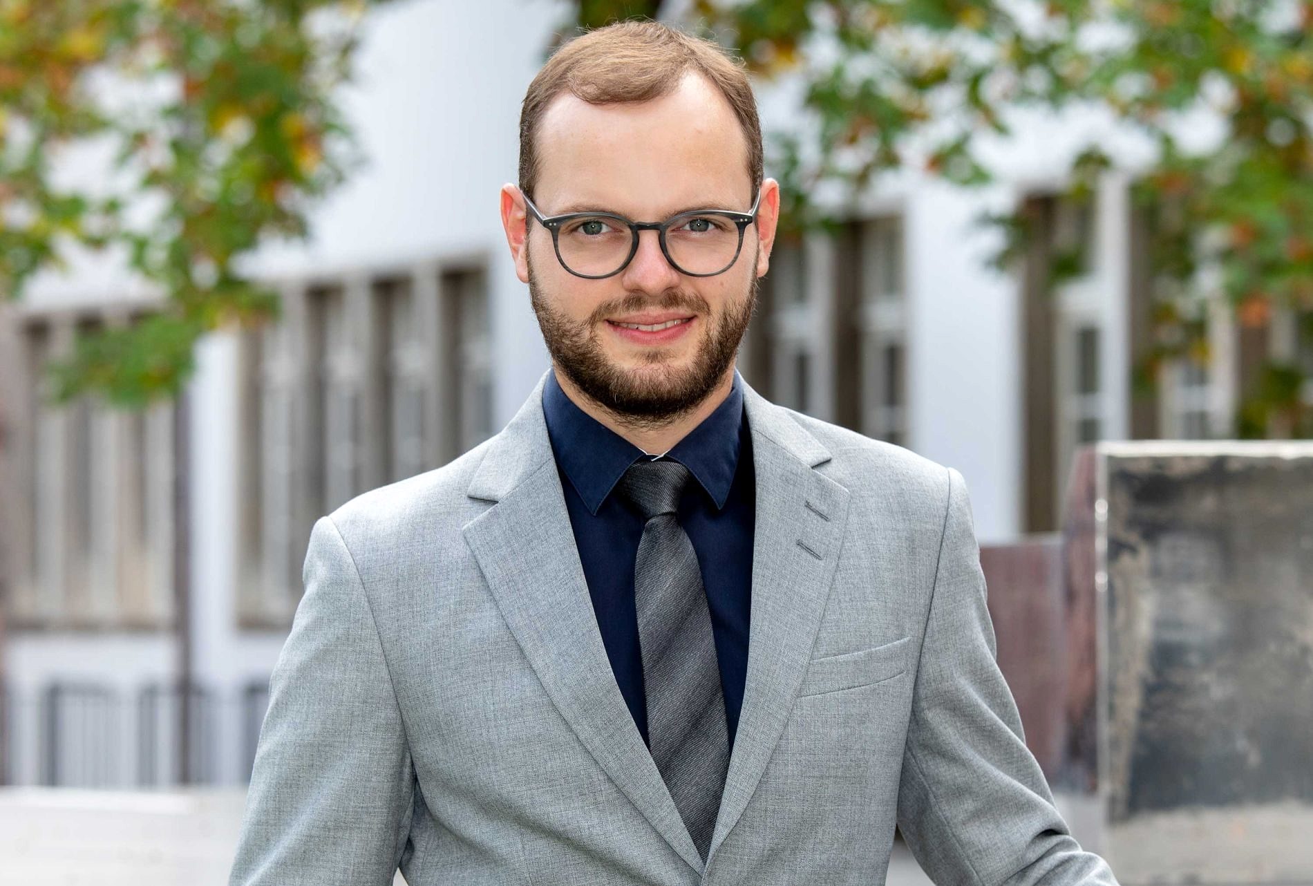 Weiß in Anzug vor Gebäude