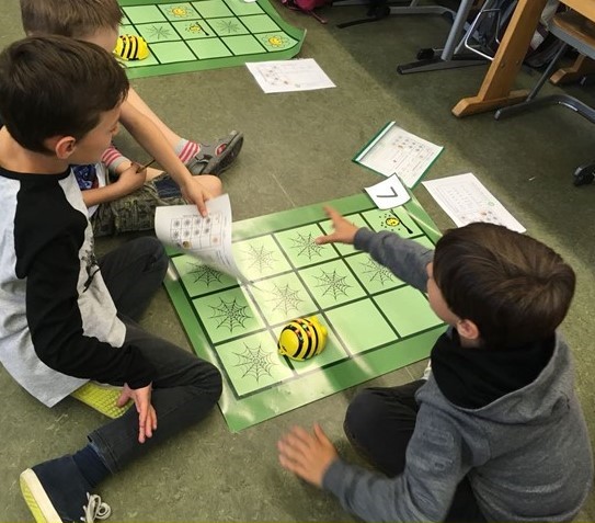 Kinder spielen am Boden auf Spielbrett