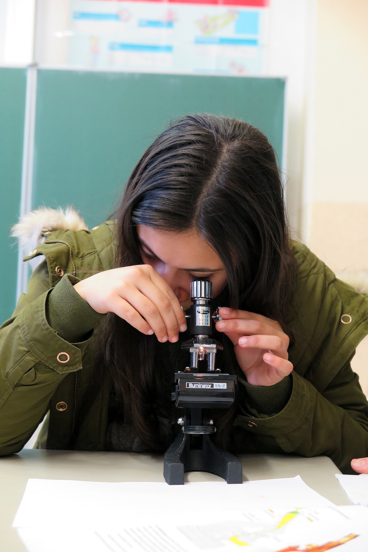 Schülerin an Mikroskop