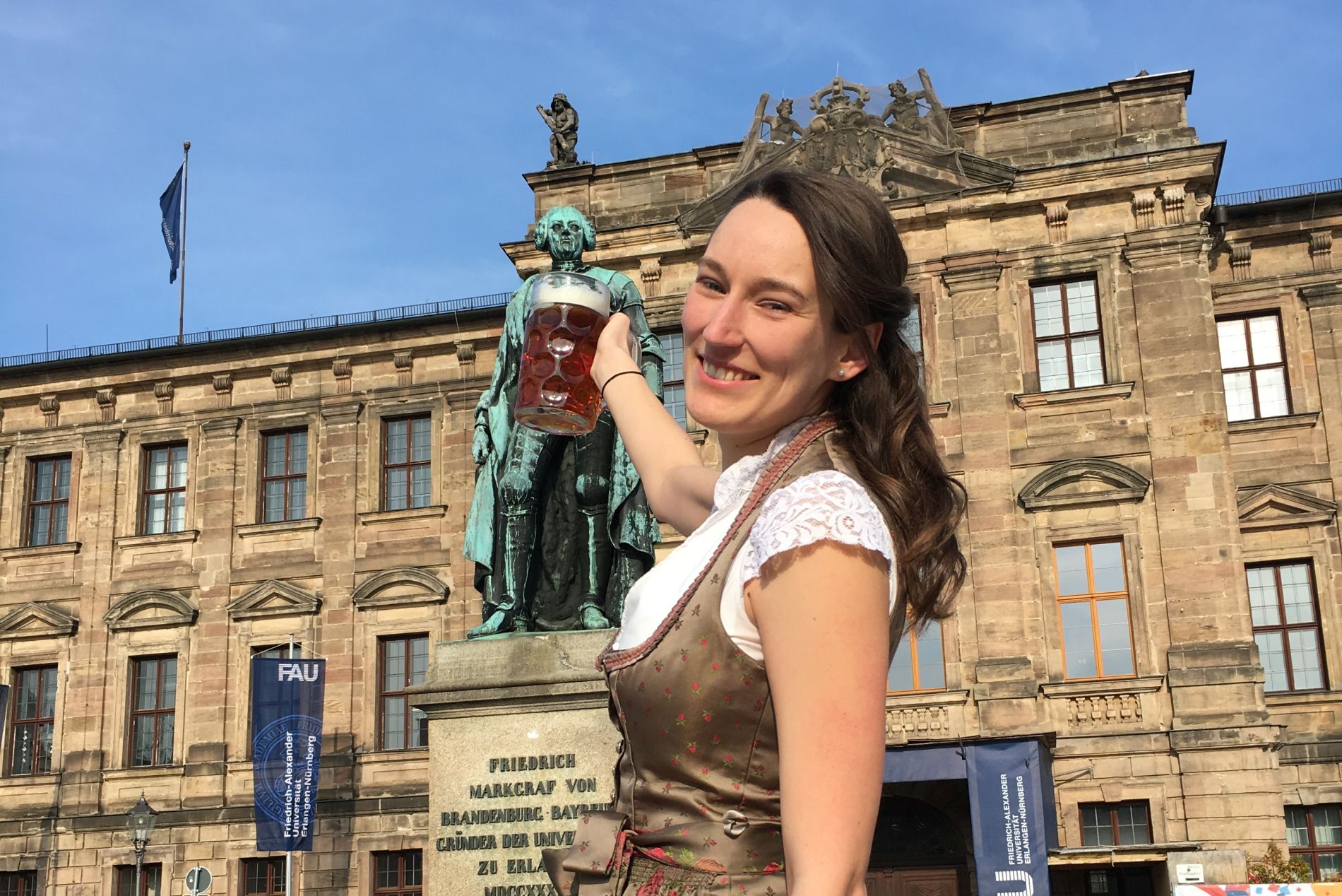 Strobl mit Bierkrug und Dirndl vor Schloss