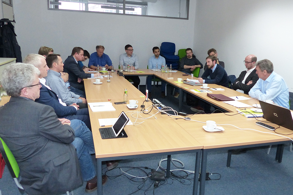 Eine Gruppe aus Männern, die in einem Konferenzraum sitzen und in einer Besprechung sind.