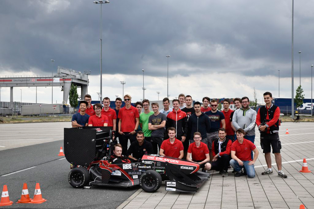 Gruppenfoto mit den Studierenden: Im Hintergrund dunkle Wolken