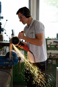 Student fräßt in der Werkstatt und die Funken sprühen dabei.