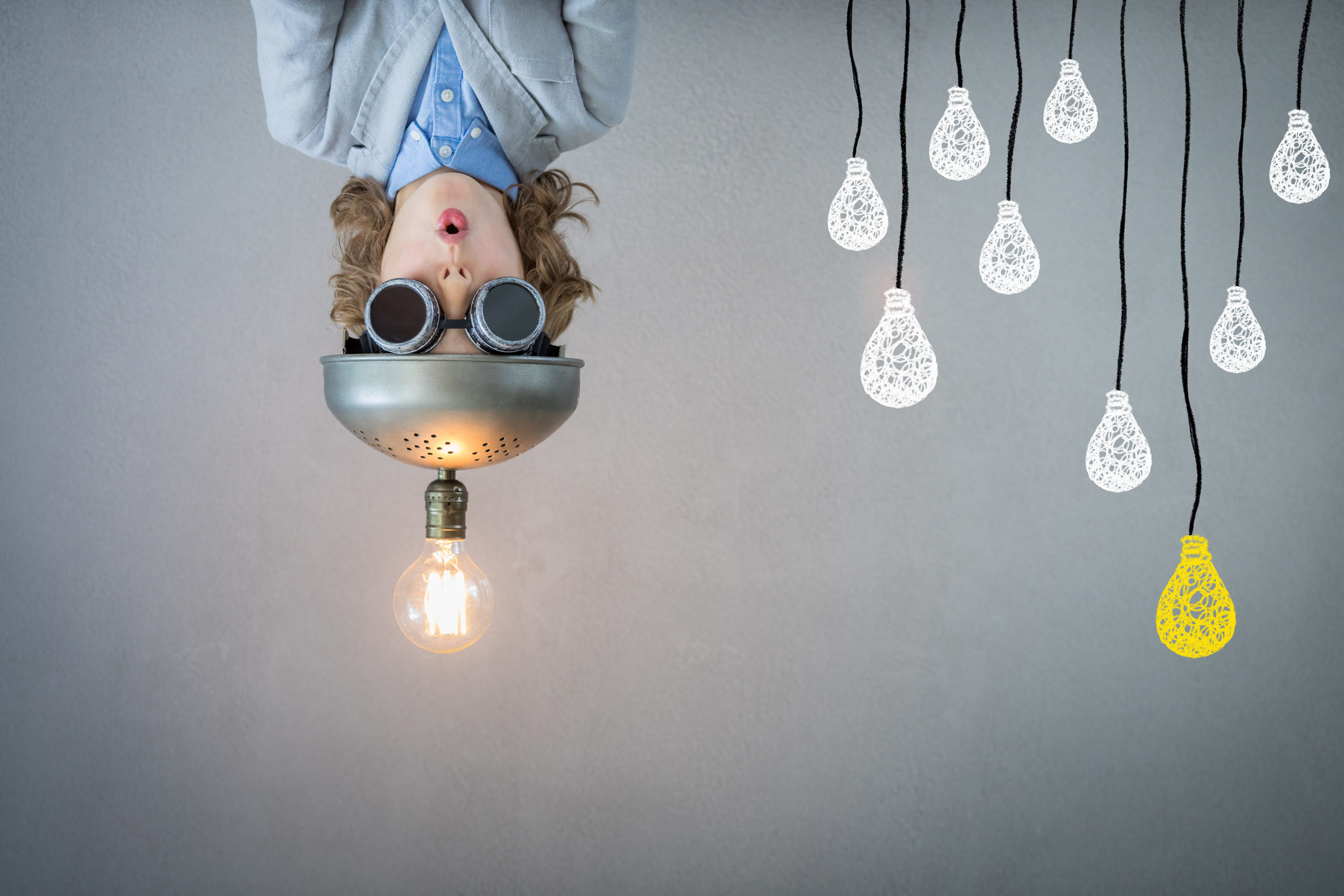 Person mit Helm neben gezeichneten Glühbirnen