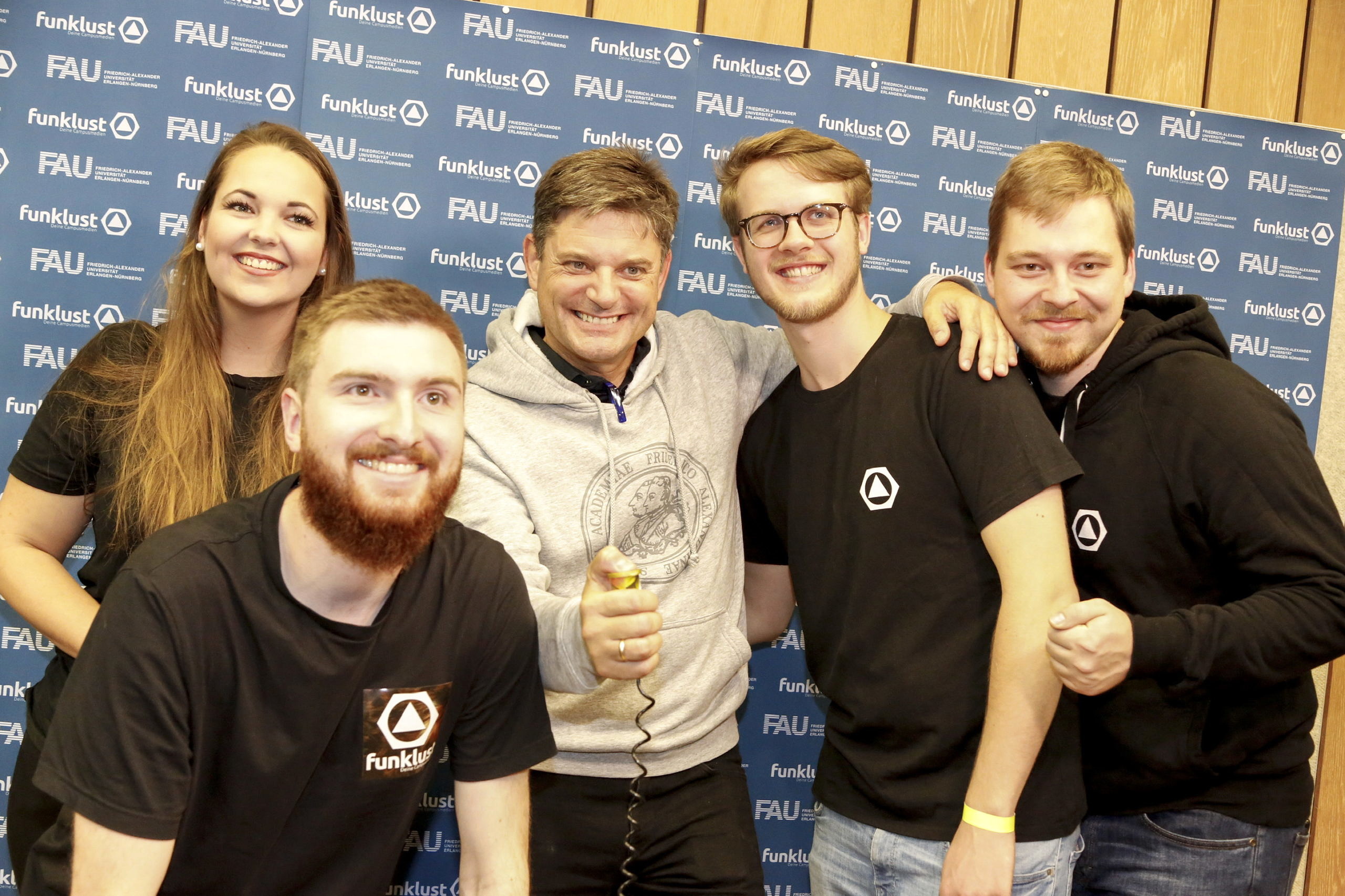 Studierende vor Fotowand mit FAU-Präsident