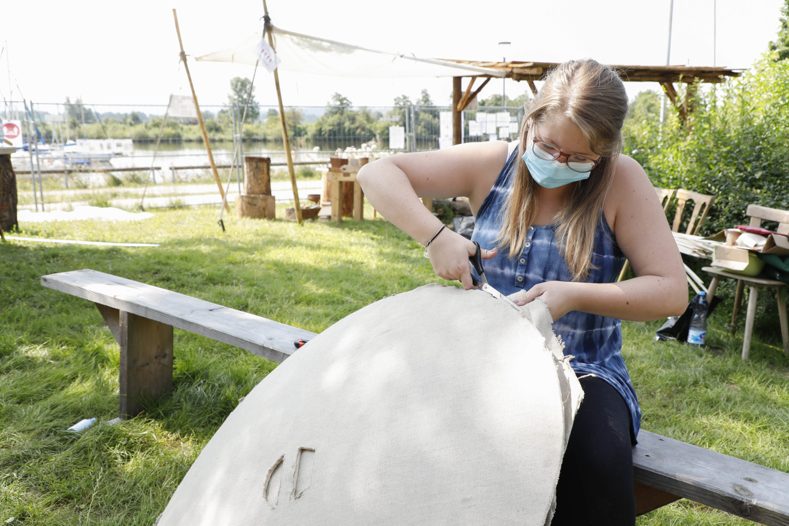 Eine Frau sitzt auf einer Bank und arbeitet an einem römischen Schild.