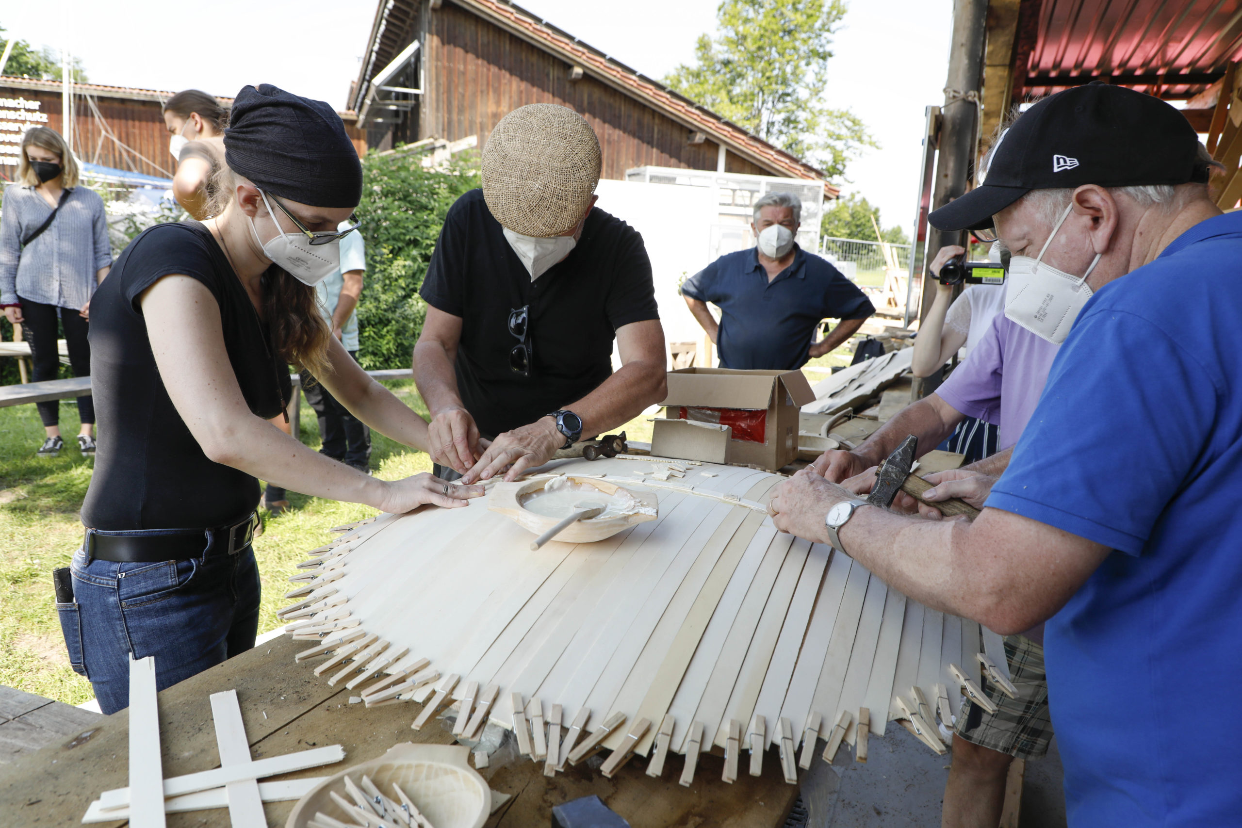 Gruppe von Menschen baut ein römisches Schild nach.