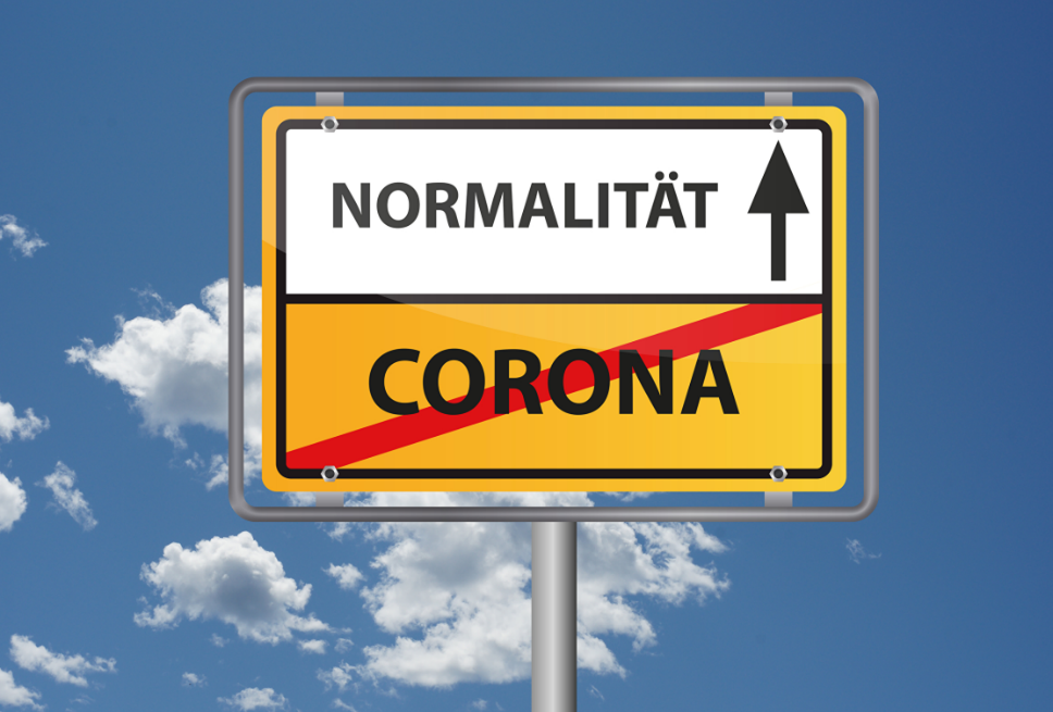 Straßenschild zeigt das Wort Corona durchgestrichen und das Wort Normalität mit einem Pfeil nach oben