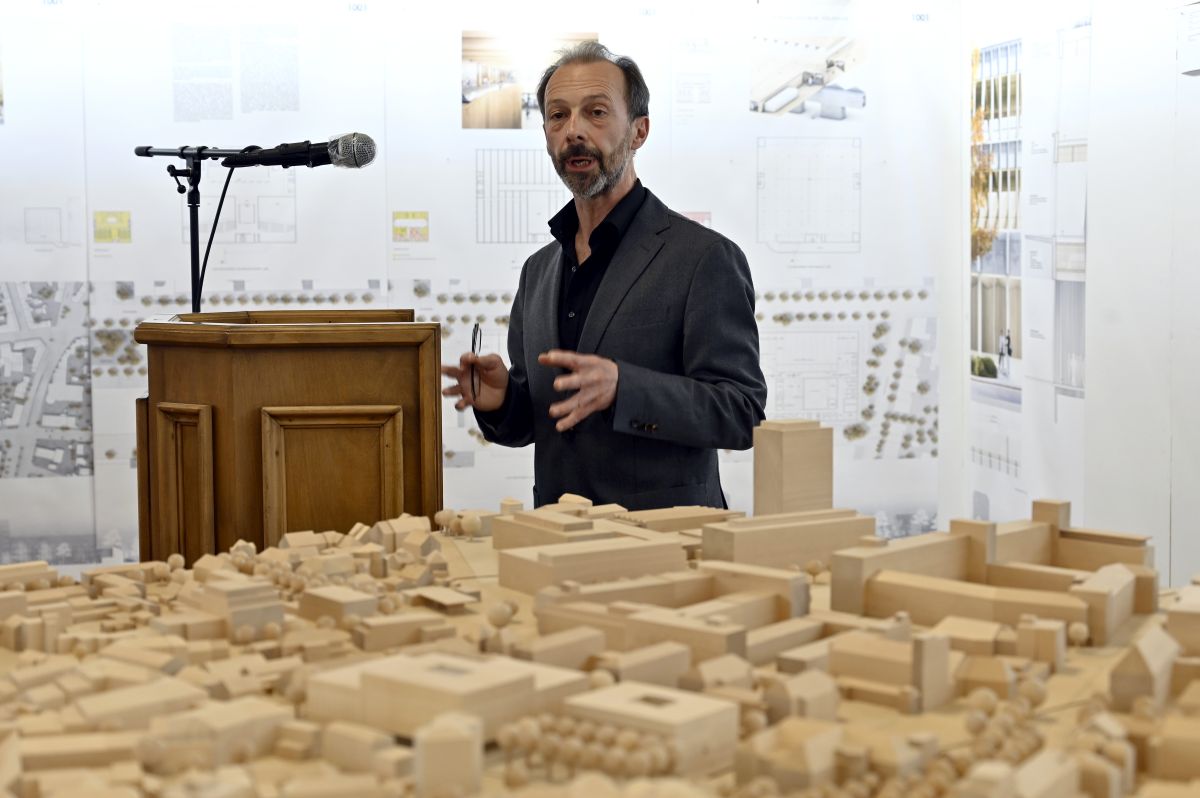 Rede am Rednerpult vor Modell des Hörsaalzentrums