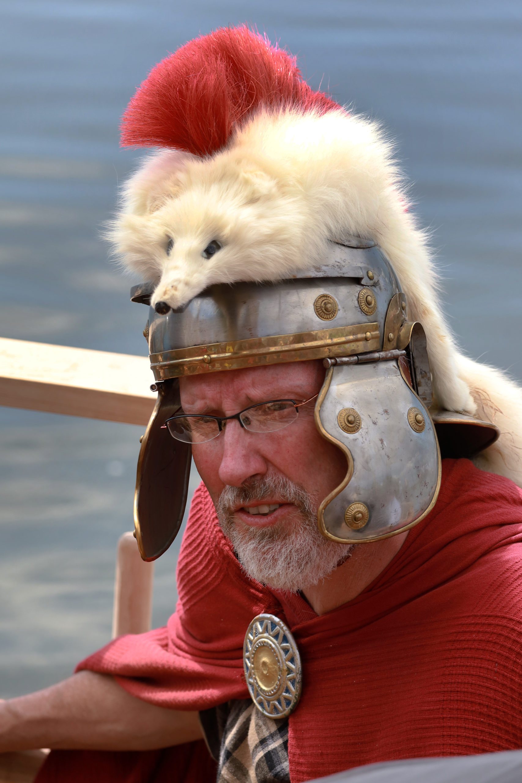 Mann mit Römerverkleidung inklusive Helm auf dem ein Tierfell mit rotem Kamm angebracht ist