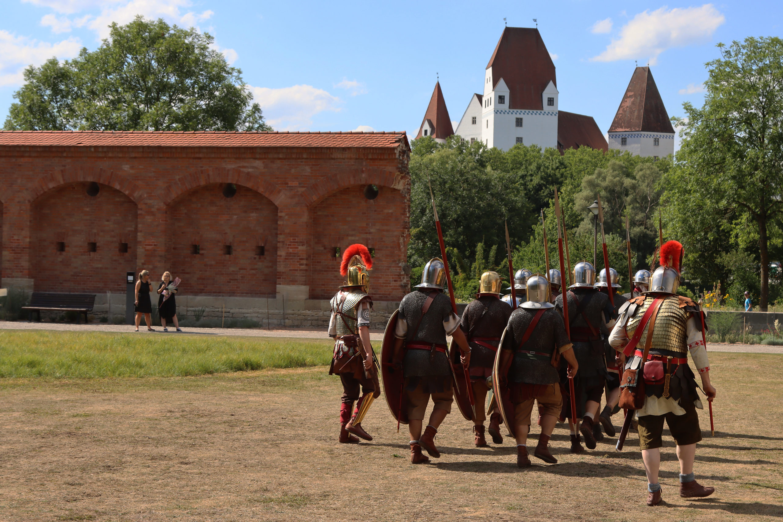 Eine kleine Gruppe römischer Reeanctmanet-Darsteller marschieren auf einem Feld.