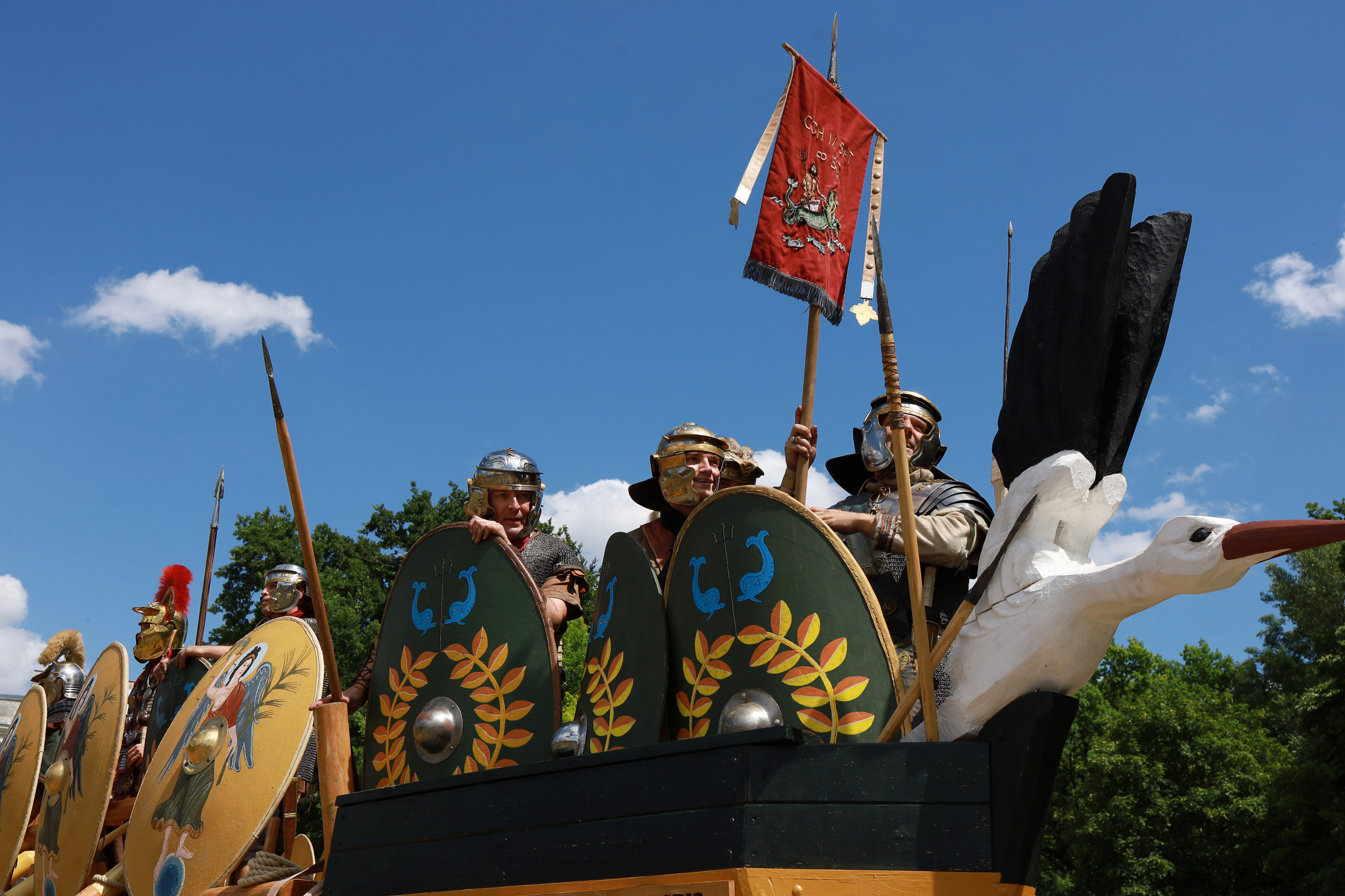 Im Bug eines Römerbootes stehen sechs Männer in römischen Soldatenuniformen.